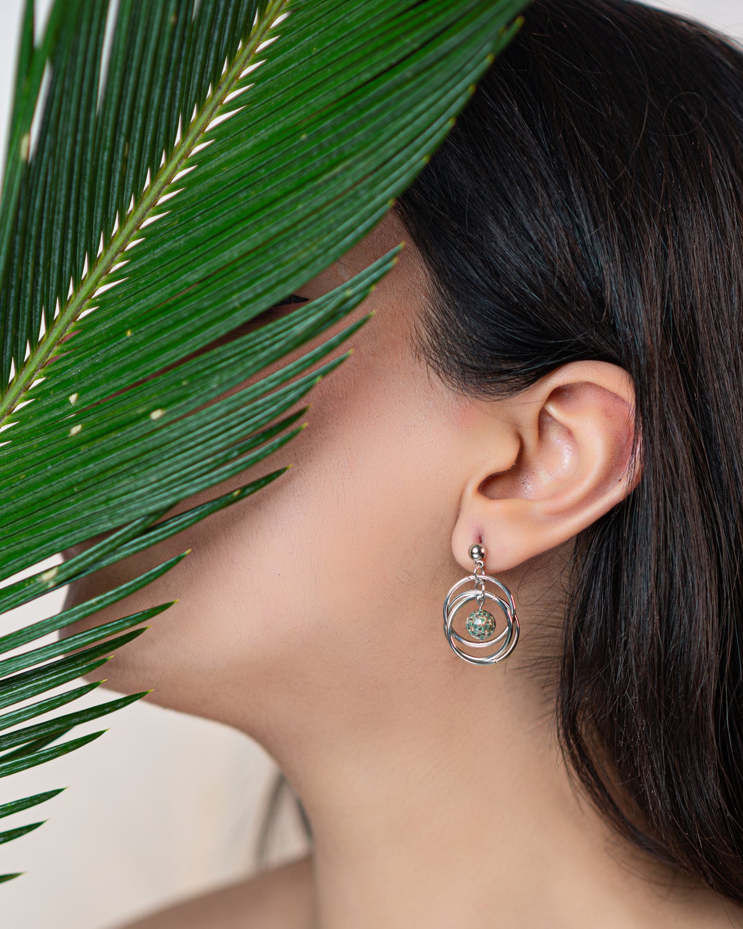 Boucles d'oreilles pendantes avec multiples anneaux et une perle à motifs