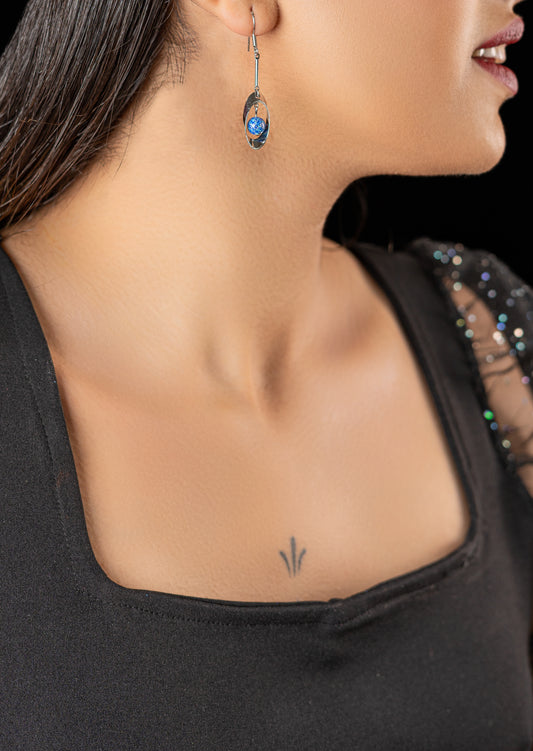 boucles d'oreilles pendantes avec un anneau et une perle bleue suspendue à l'intérieur.