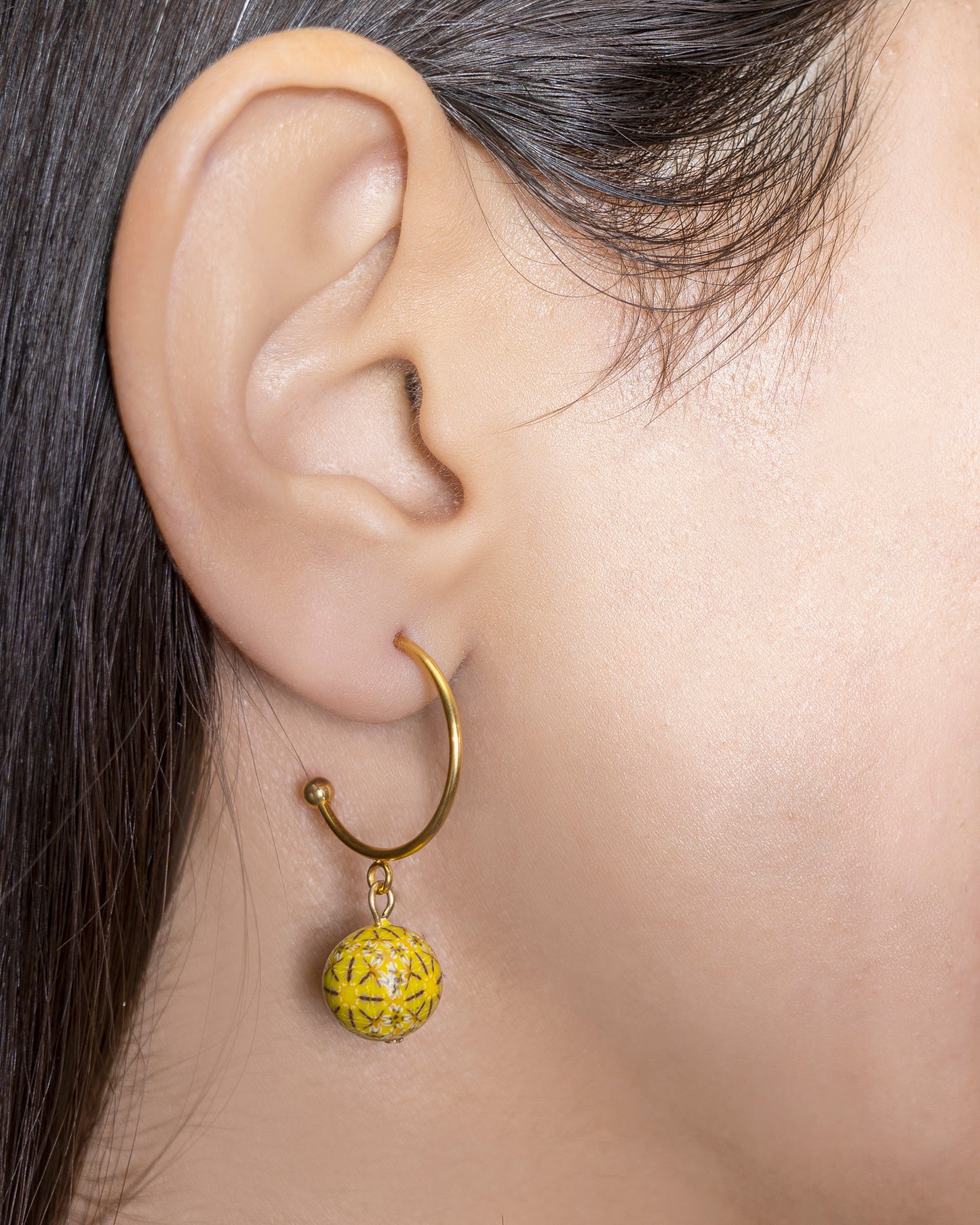 boucles d'oreilles pendantes fantaisies créoles avec une perle jaune suspendue 