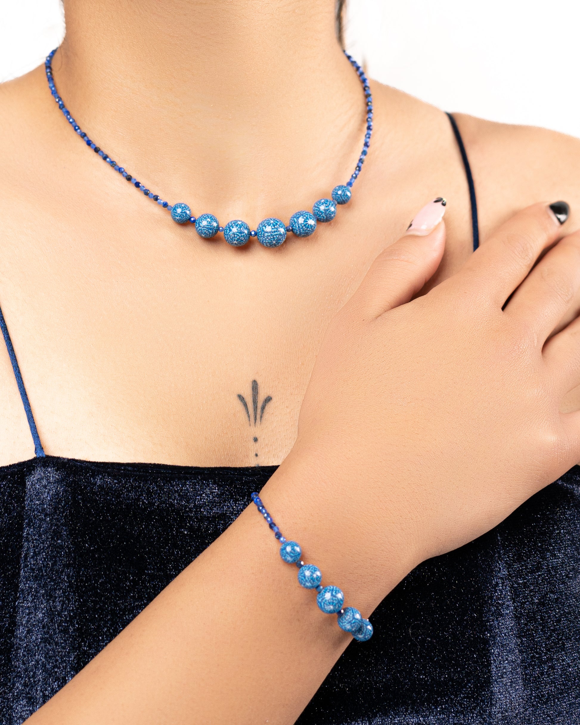 Parure de bijoux avec un collier et un bracelet en perles bleues pour femmes.