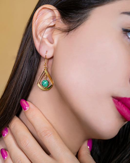 boucles d'oreilles longues en forme de triangle et une perle verte à motifs